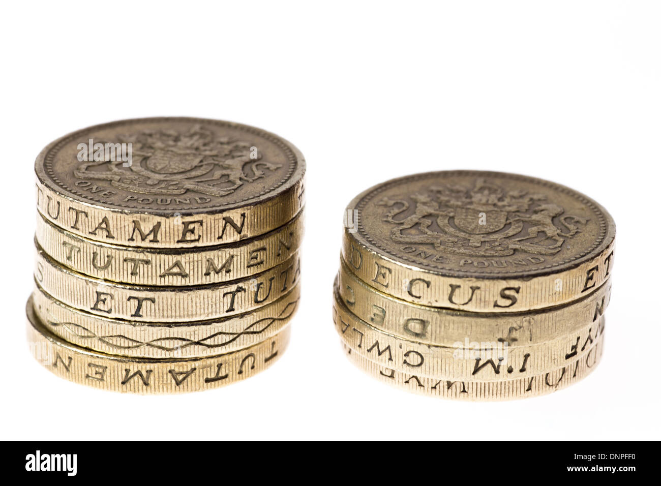 Two unequal piles of British one pound coins Stock Photo