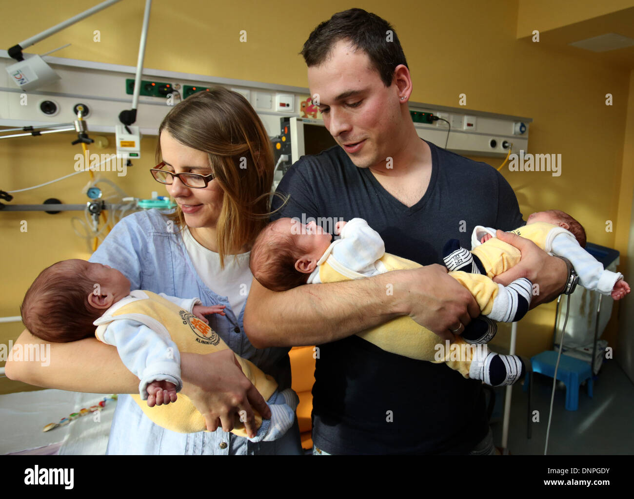 Rostock, Germany. 03rd Jan, 2014. The triplets (LR) Till, Max and Ben lie in the arms of their