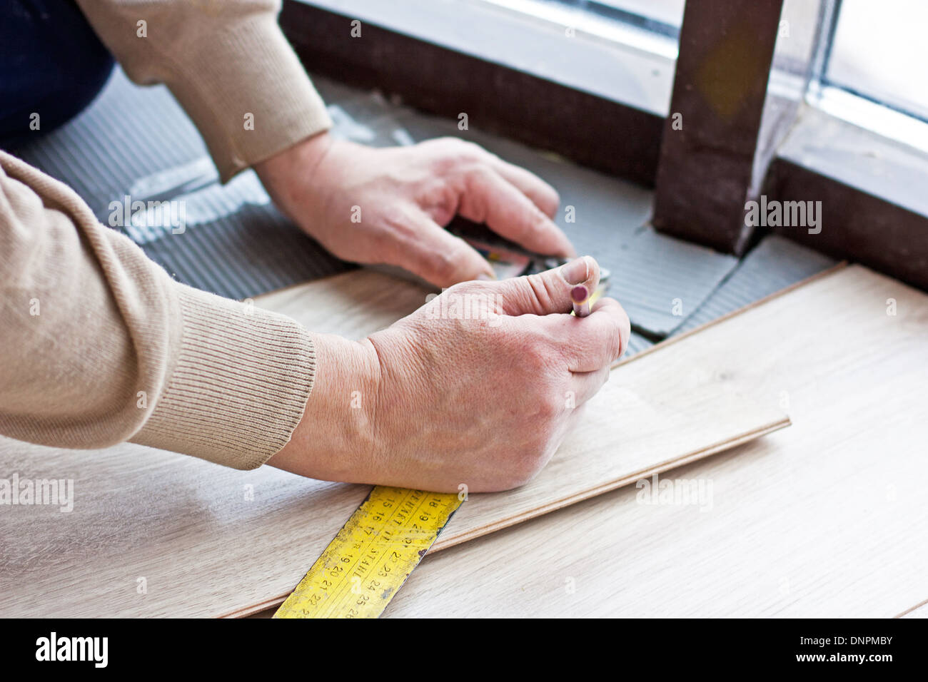 worker makes markup before laying laminate flooring Stock Photo Alamy