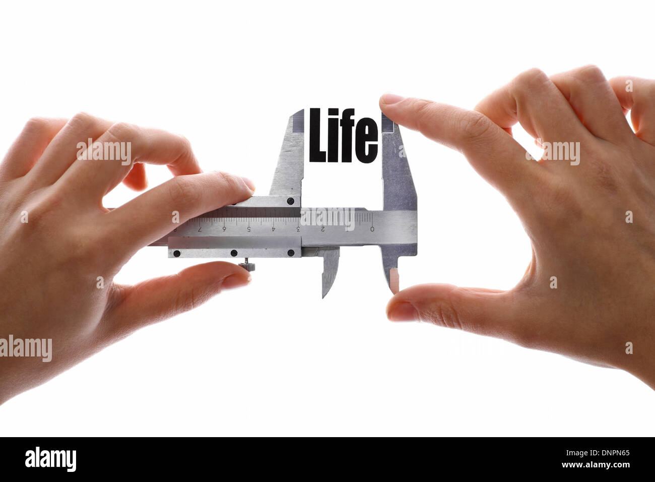 Two hands holding a caliper, measuring the word 'Life'. Stock Photo