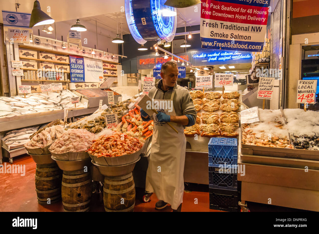 Fish monger setting up a display in a market stall Pike Place Market Seattle, Washington, USA Stock Photo