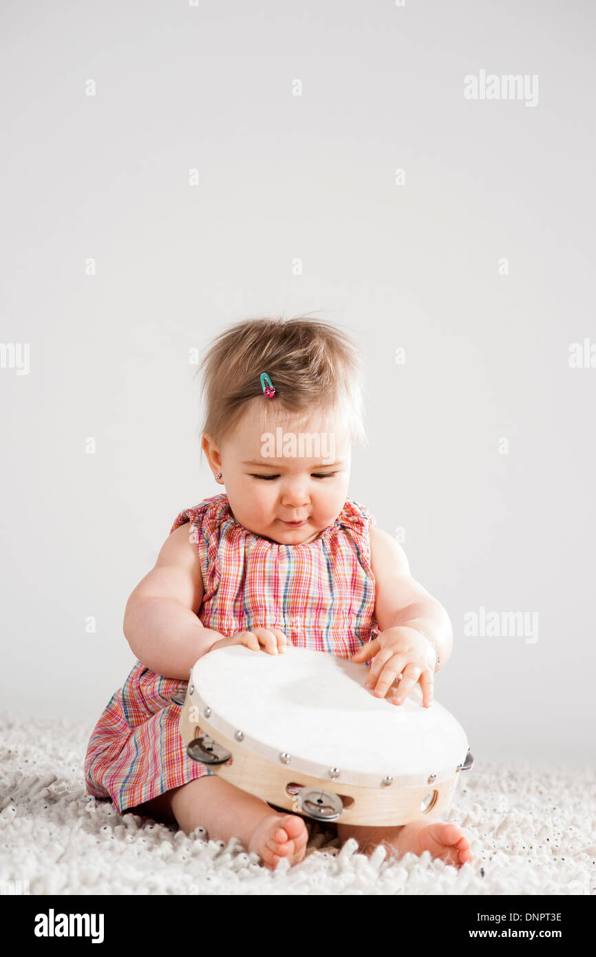 Portrait of Baby Girl holding Tambourine, Studio Shot Stock Photo - Alamy