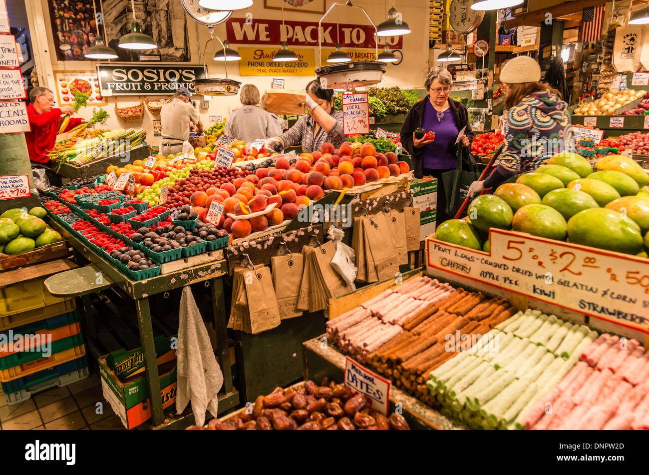 Shoppers select fresh produce in a market stall Pike Place Market Seattle, Washington, USA Stock Photo