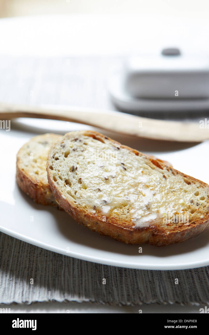 Closeup of Buttered Multigrain Toast with Wooden Knife, Studio Shot