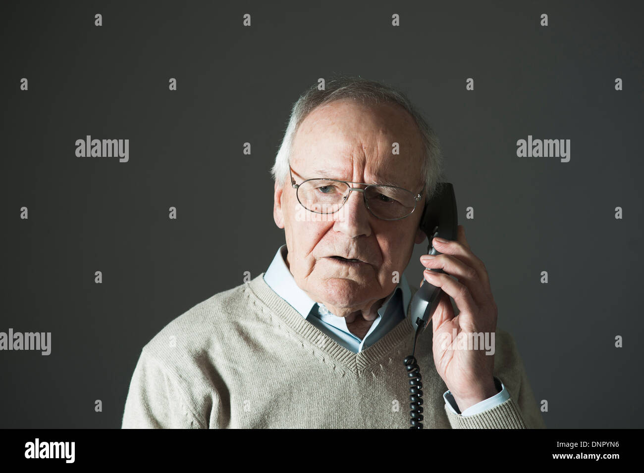 Elderly Man Talking on Phone in Studio Stock Photo