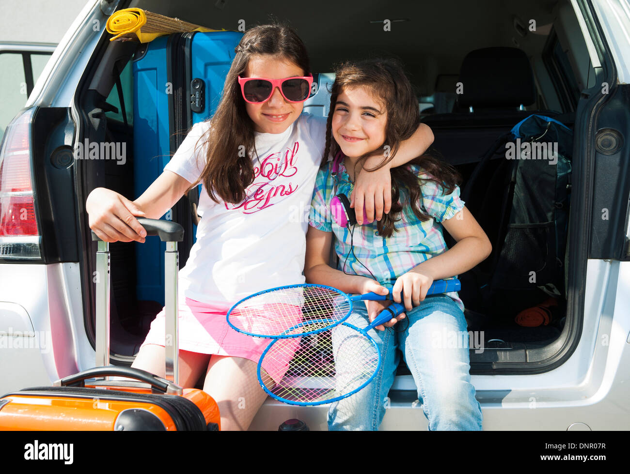 Portrait of Sisters in Trunk of Van Getting ready for Vacation, Mannheim, Baden-Wurttemberg, Germany Stock Photo