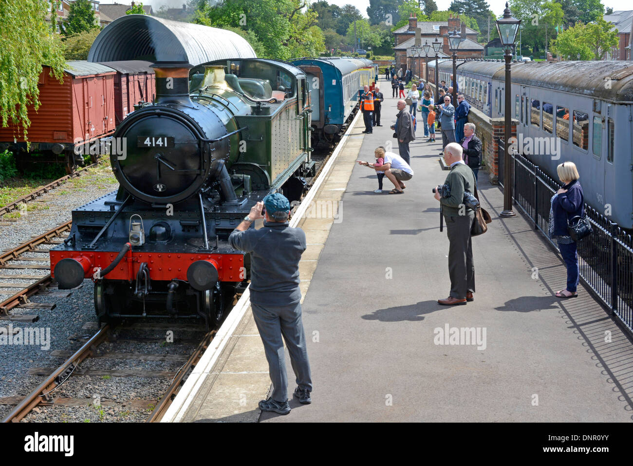 Enthusiasts on the platform at Ongar watching steam locomotive 4141 on the Epping Ongar heritage railway Essex England UK Stock Photo