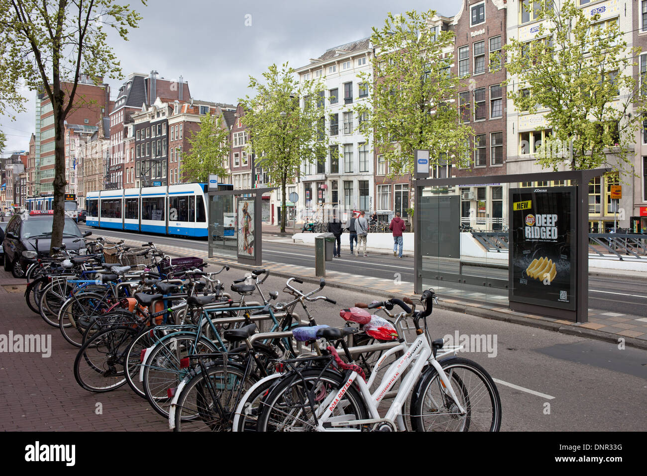 Bikes and tram stop on Nieuwezijds Voorburgwal street in Amsterdam