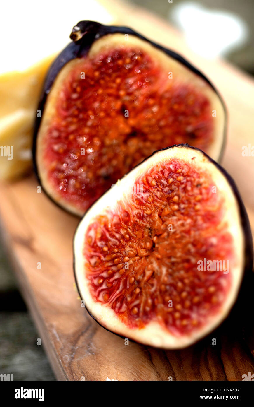 Freshly cut ripe fig on olive wood board Stock Photo - Alamy