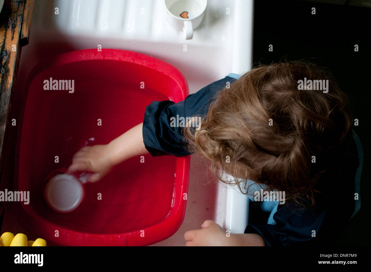 toddler playing at sink Stock Photo