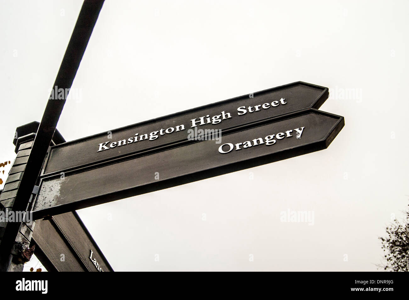 Black metal signpost to Kensington High Street and Orangery, in Kensington Gardens, London. Stock Photo