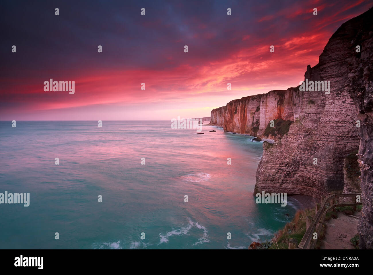 dramatic sunrise over ocean and cliffs, Etretat, France Stock Photo