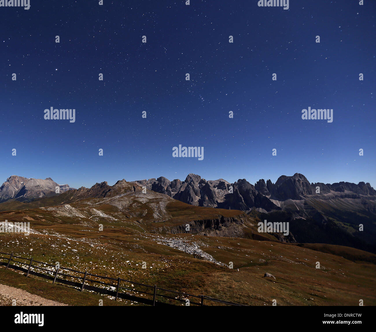 Moonlight on the Catinaccio mountain massif. The Dolomites. View from the Sciliar massif. Italian Alps. Night landscape. Europe. Stock Photo