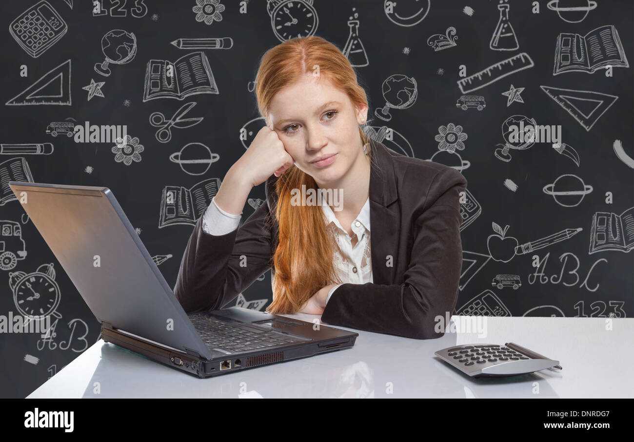 Young well dressed red haired Girl is sitting frustrated in front of the computer Stock Photo