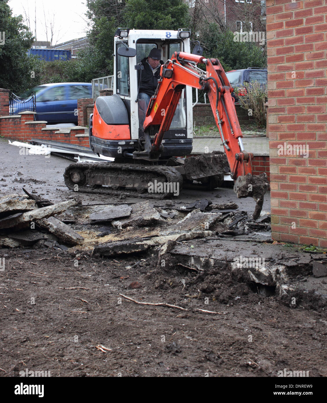 A mini digger being used in the preparation of groundwork for the laying of blockpaving Stock Photo