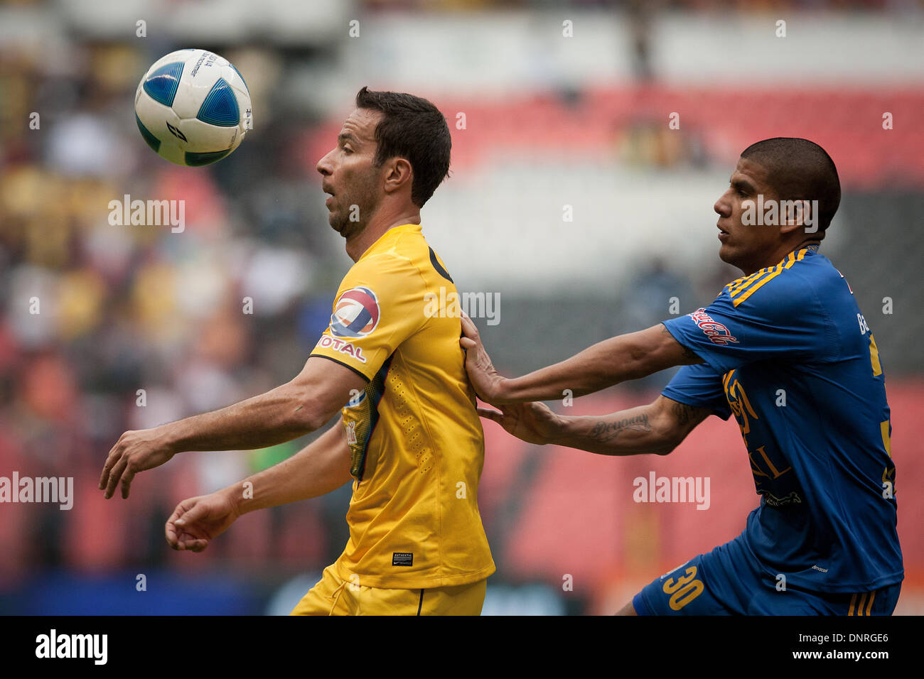 Mexico City, Mexico. 4th Jan, 2014. Luis Gabriel Rey (L) of America vies for the ball with Carlos Salcido of Tigres during their match of the MX League Closing Tournament 2014, held in the Azteca Stadium, in Mexico City, capital of Mexico, on Jan. 4, 2014. Credit:  Pedro Mera/Xinhua/Alamy Live News Stock Photo