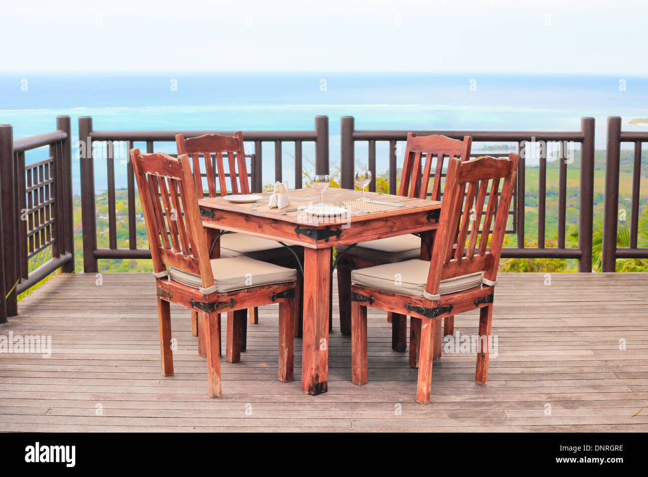 Outside dining table and chairs on a wooden balcony Stock Photo