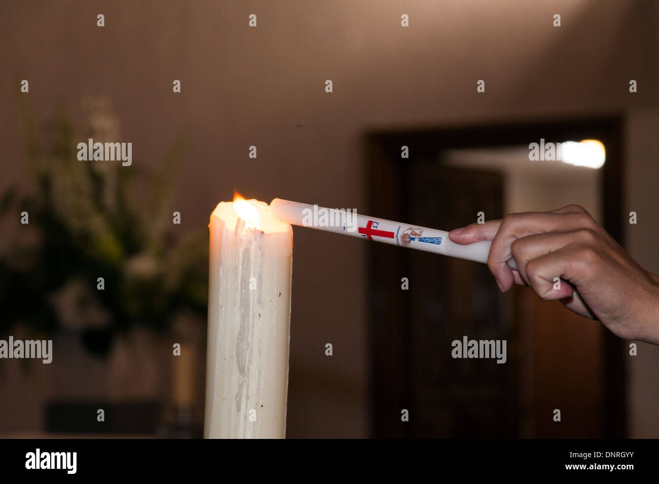 Baptismal candle lighting in a religious ceremony in a church Stock Photo