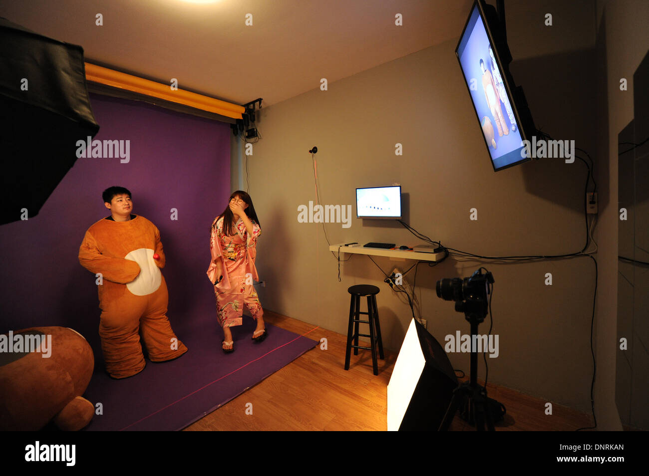 (140105) -- HANGZHOU, Jan. 4, 2014 (Xinhua) -- Two customers laugh as they see the selfies on the screen at the self shooting studio of Ke Yunxia and her partners in Hangzhou, east China's Zhejiang Province, Jan. 2, 2014. The self-shooting studio set up by Ke and her three friends was opened the same day on which 'Selfie' was named word of 2013 by Oxford Dictionaries editors in November of 2013. Selfie is not only a popular word, it's also given some graduates new way to establish their own business. In the studio, customers are not only a subject, but also a photographers. They can choose the Stock Photo