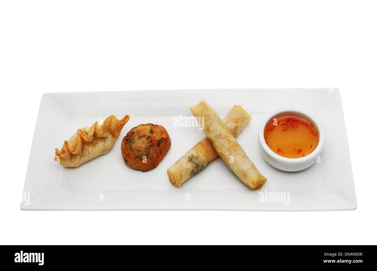 Chinese Dim sum with a sweet chilli dip on a rectangular plate isolated against white Stock Photo