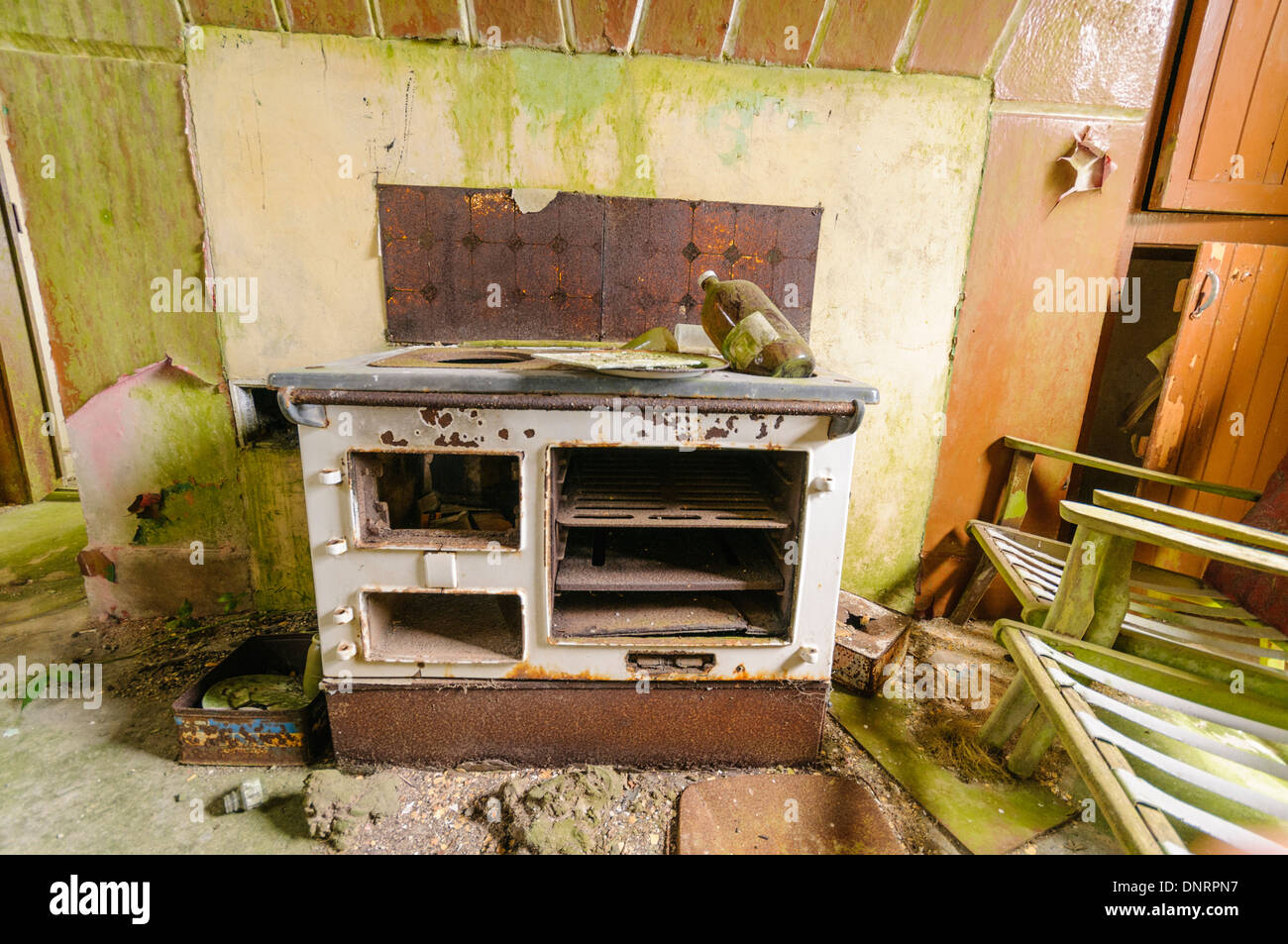 Rusting and broken old range cooker in an abandoned house Stock Photo