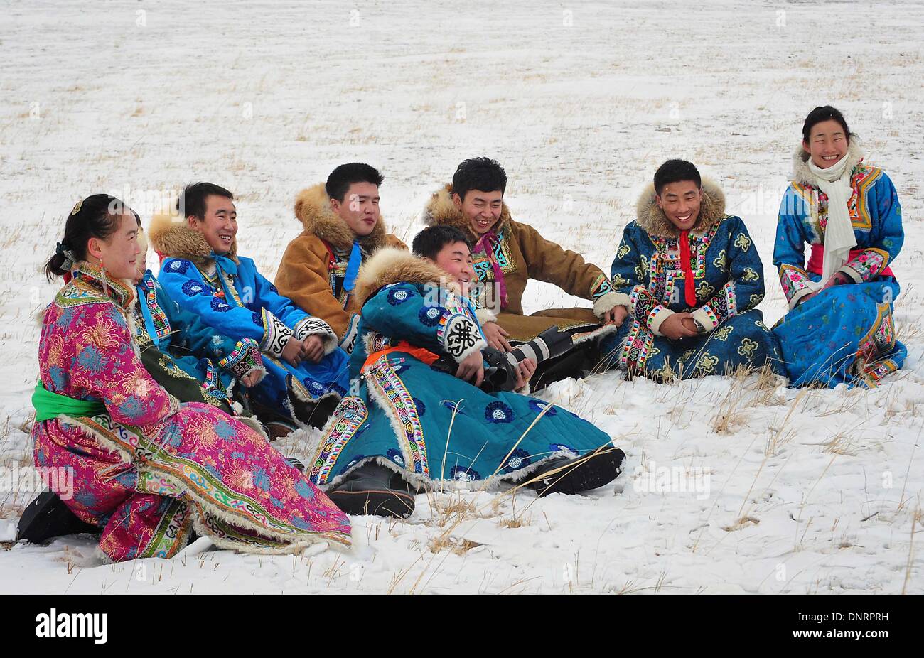 West Ujimqin Banner, China's Inner Mongolia Autonomous Region. 4th Jan, 2014. Young men and women in traditional holiday attire of the Mongolian ethnic group play on the snowfield at an ice and snow carnival in West Ujimqin Banner, north China's Inner Mongolia Autonomous Region, Jan. 4, 2014. The winter carnival lasts from Jan. 4 to Jan. 5 here. Credit:  Wang Song/Xinhua/Alamy Live News Stock Photo
