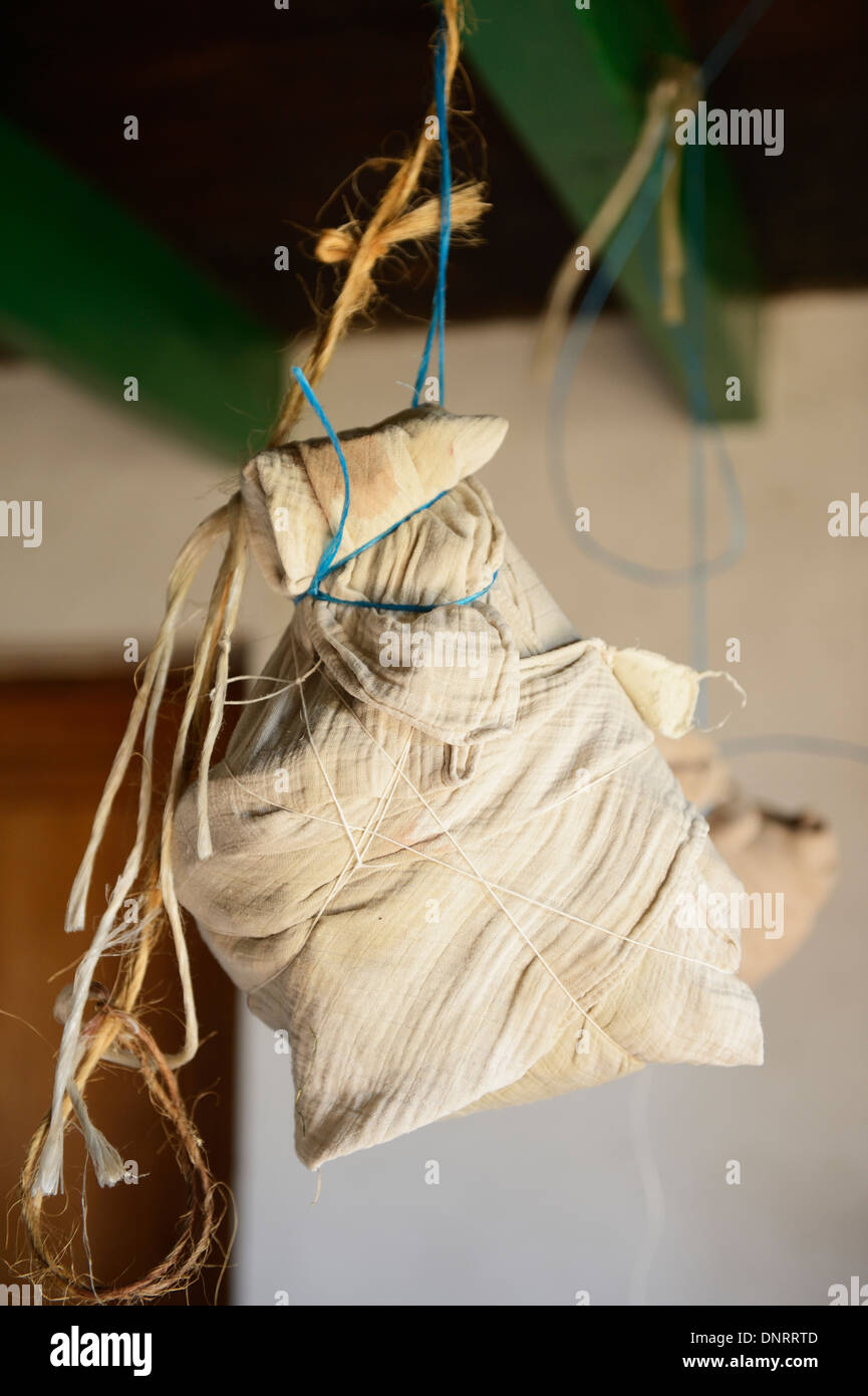 Ham hocks tied in muslin hanging from the ceiling whilst being dried Stock Photo