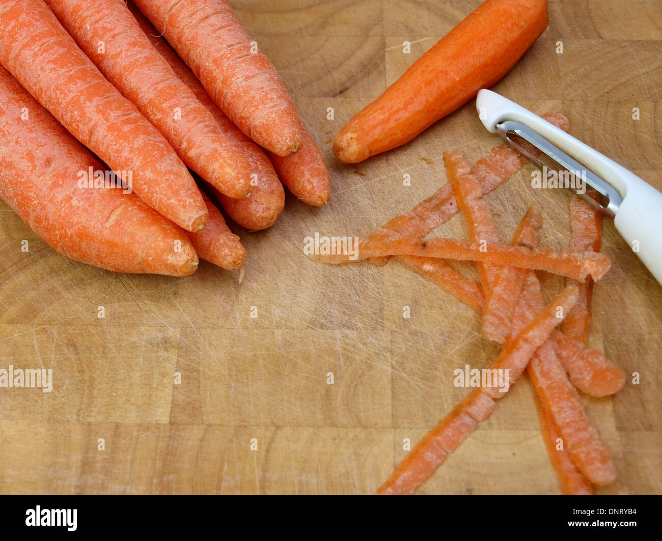 Peeling carrots on a chopping board Stock Photo Alamy