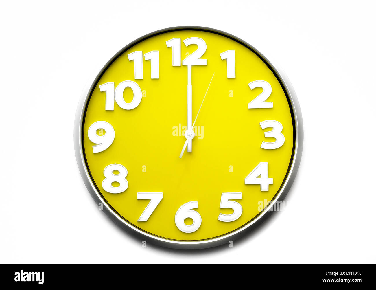 yellow clock face midday 12 o'clock the clock strikes twelve 12 midnight 00.00 Stock Photo