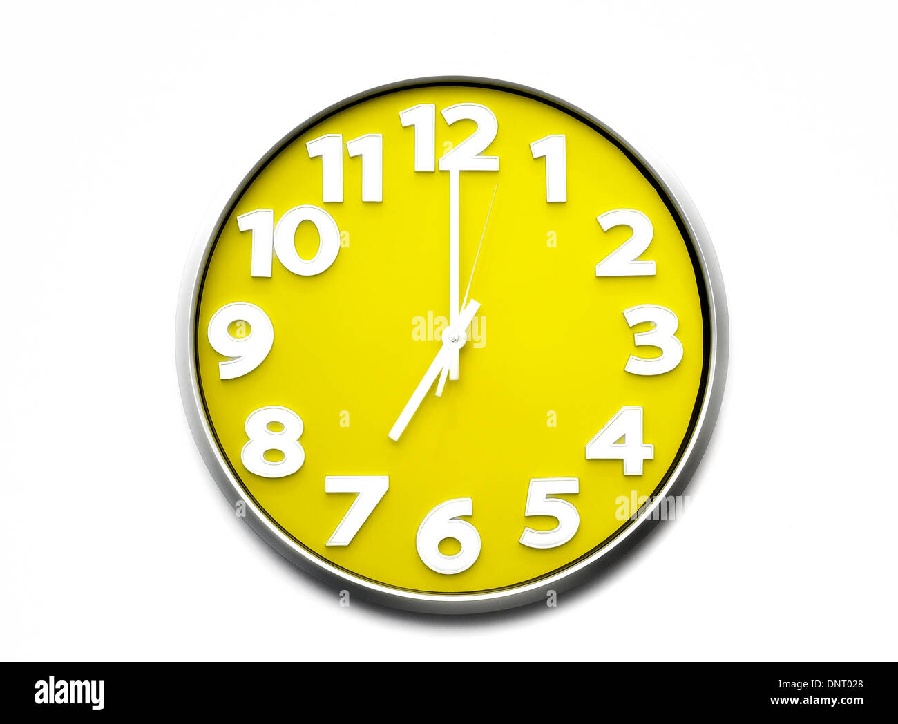 yellow clock face 7 o'clock the clock strikes seven 1900 hours Stock Photo