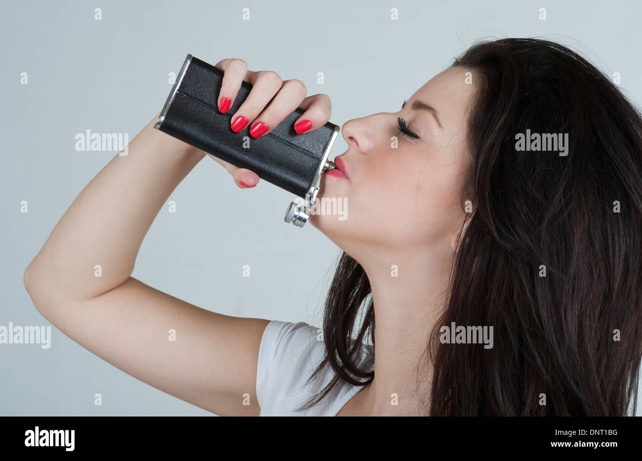 Young woman drinking from a hip flask Stock Photo - Alamy