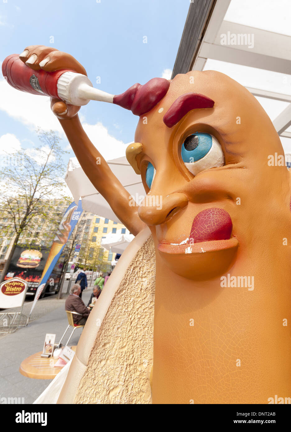 A character hot dog street stand covering itself in ketchup whilst licking its lips Stock Photo