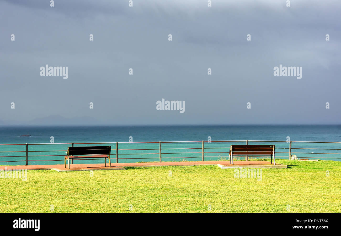 benches on cliff with sea view and stormy clouds Stock Photo