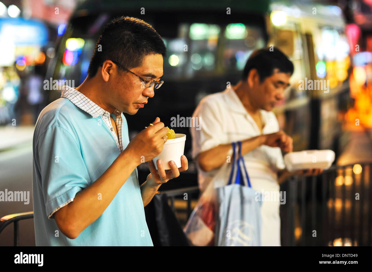 Two guys eating street food, Causeway Bay, Hong Kong Stock Photo