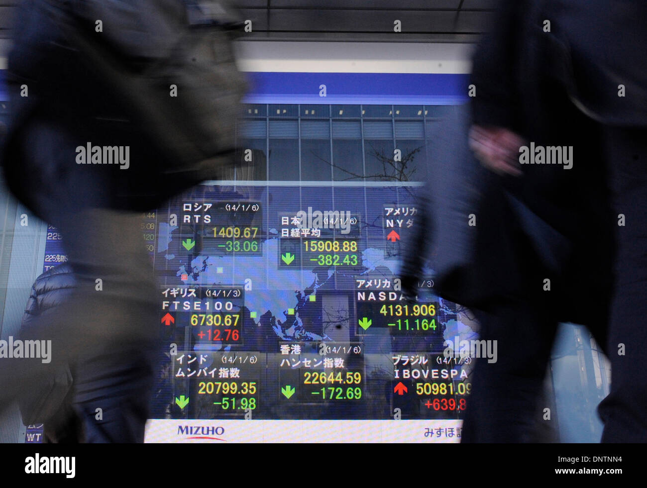 Tokyo, Japan. 6th Jan, 2014. People walk past an electronic board showing the stock index in Tokyo, Japan, Jan. 6, 2014. The 225-issue Nikkei Stock Average closed down 382.43 points from the end of 2013 at 15,908.88. Credit:  Stringer/Xinhua/Alamy Live News Stock Photo