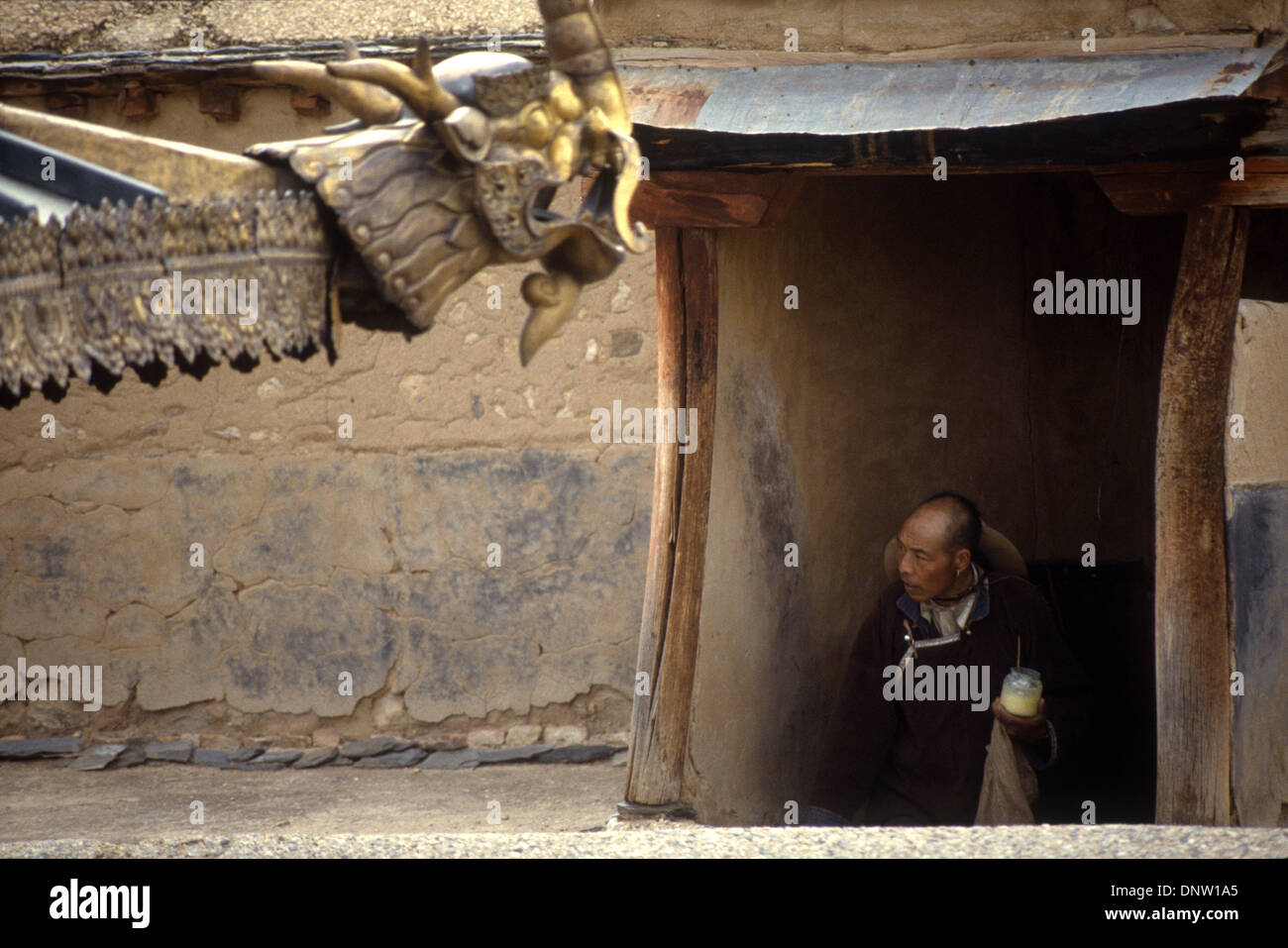 A pilgrim climbing stairs to the roof of a temple in Lhasa, Tibet, China Stock Photo