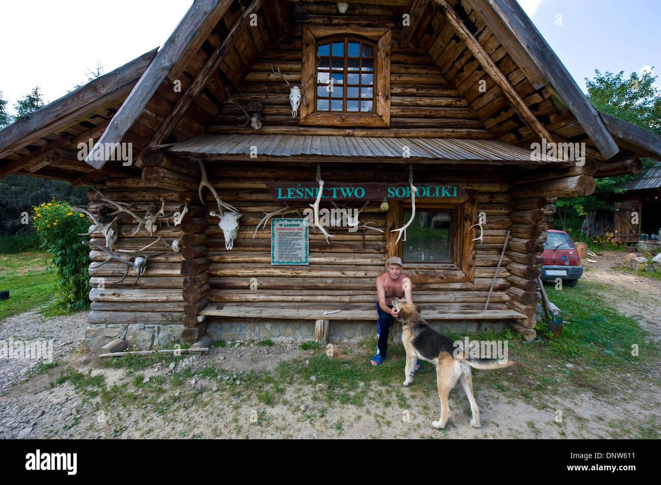 A Lumberjack With His Dog In Front Of A Timber House Decorated
