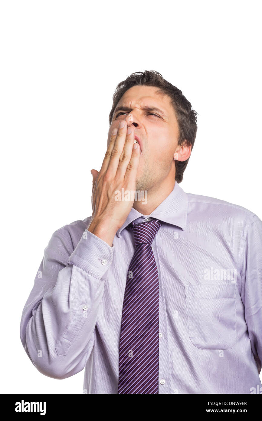 Young businessman in shirt and tie yawning Stock Photo