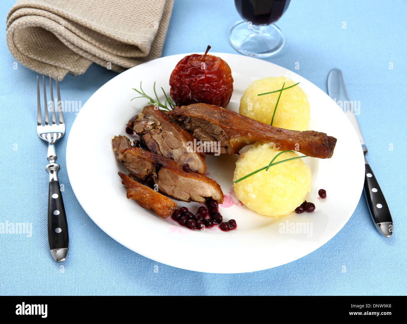 Duck leg with potato dumplings, red apple and cranberries, top view Stock Photo
