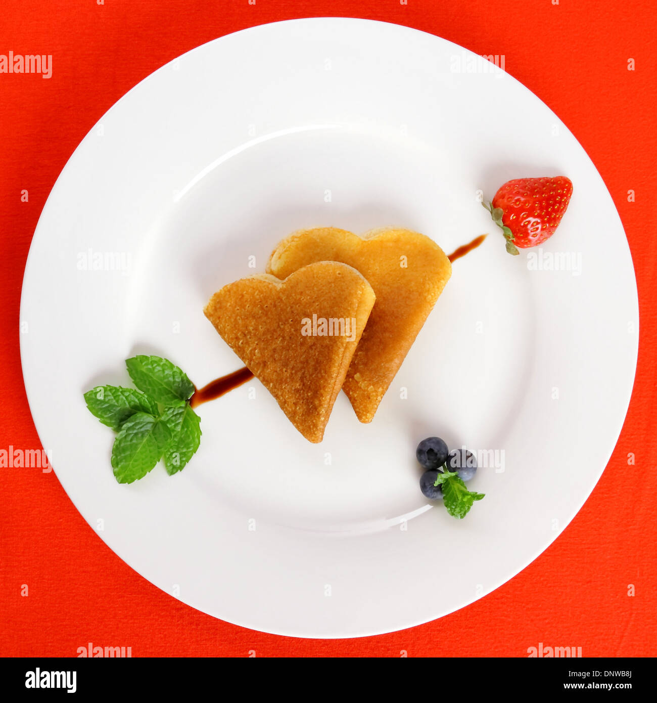 Two pancakes heart and chocolate, strawberry, mint arrow, top view Stock Photo