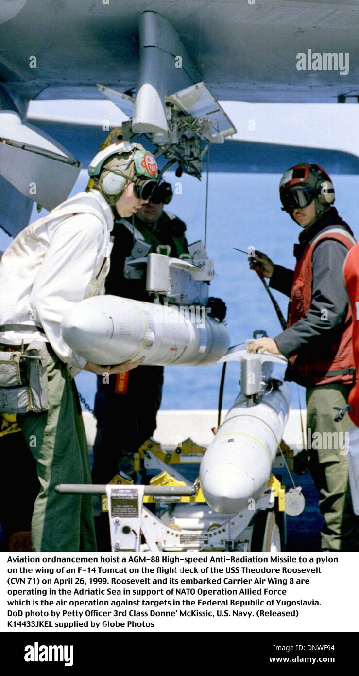 May 1, 1999 - Uss Theodore Roosevelt (Cvn 71 - K14433JKEL    04/26/99.990426-N-7280M-002..Aviation ordnancemen hoist a AGM-88 High-speed Anti-Radiation Missile to a pylon on the wing of an F-14 Tomcat on the flight deck of the USS Theodore Roosevelt (CVN 71) on April 26, 1999.  Roosevelt and its embarked Carrier Air Wing 8 are operating in the Adriatic Sea is support of Operation A Stock Photo