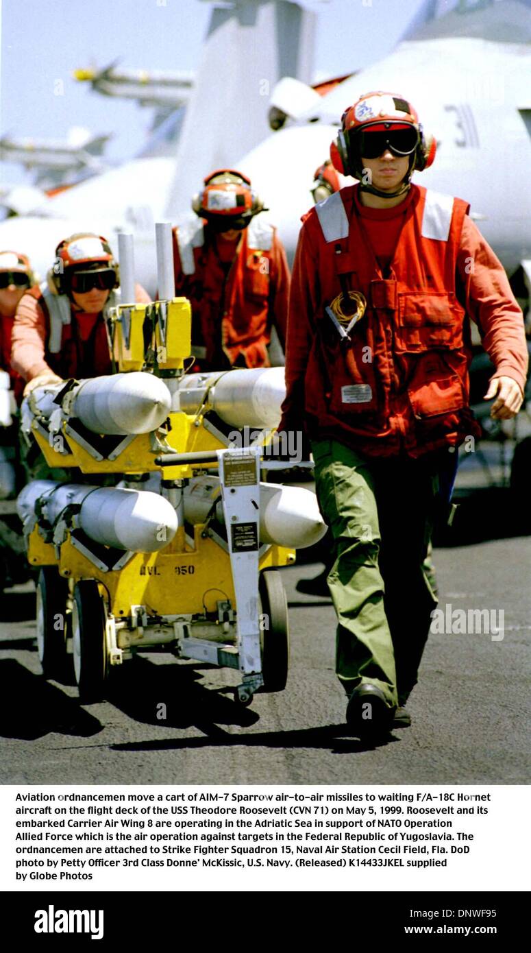 May 1, 1999 - Adriatic Sea - K14433JKEL     05/05/99.990505-N-7280M-004..Aviation ordnancemen move a cart of AIM-7 Sparrow air-to-air missiles to waiting F/A-18C Hornet aircraft on the flight deck of the USS Theodore Roosevelt (CVN 71) on May 5, 1999.  Roosevelt and its embarked Carrier Air Wing 8 are operating in the Adriatic Sea in support of NATO Operation Allied Force which is  Stock Photo