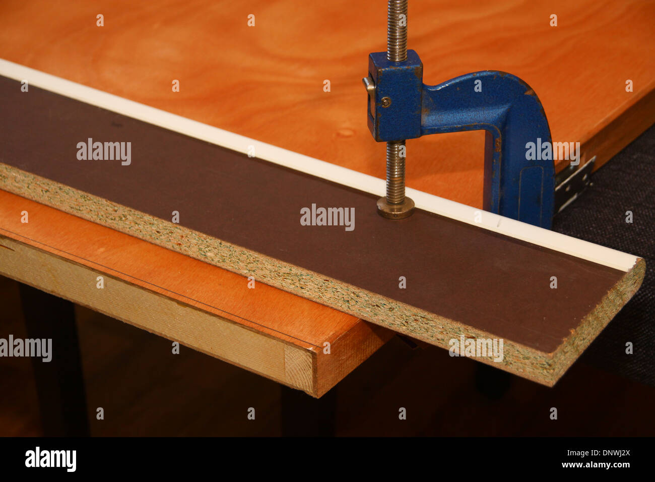 G clamp holding wooden door with scrap timber protective guide Stock Photo