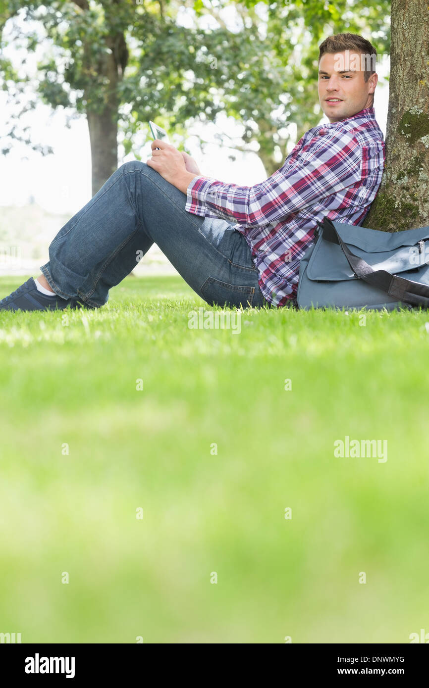 Happy student using his tablet to study outside Stock Photo