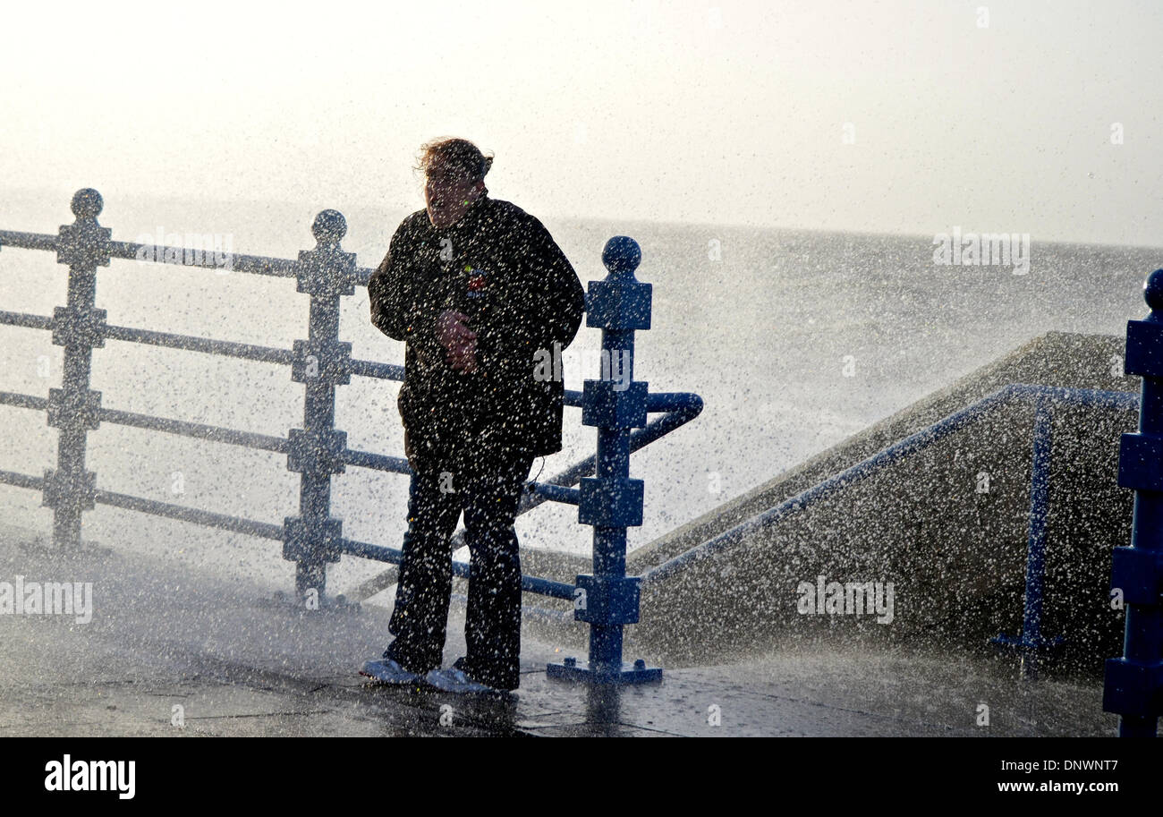 Porthcawl, Wales, UK. 06th Jan, 2014. A woman is soaked as high tides and stron winds batter the coastline at Porthcawl, Wales, UK. Credit:  Tom Guy/Alamy Live News Stock Photo