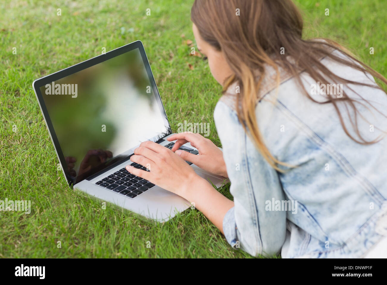 Student lying on the grass using her laptop Stock Photo - Alamy