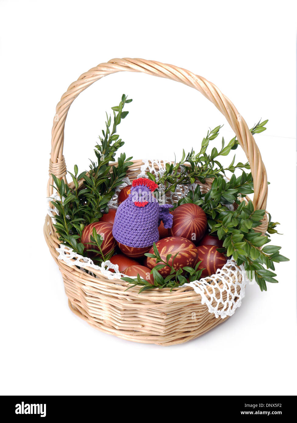 Wicker basket with easter eggs and decorations shot on white Stock Photo