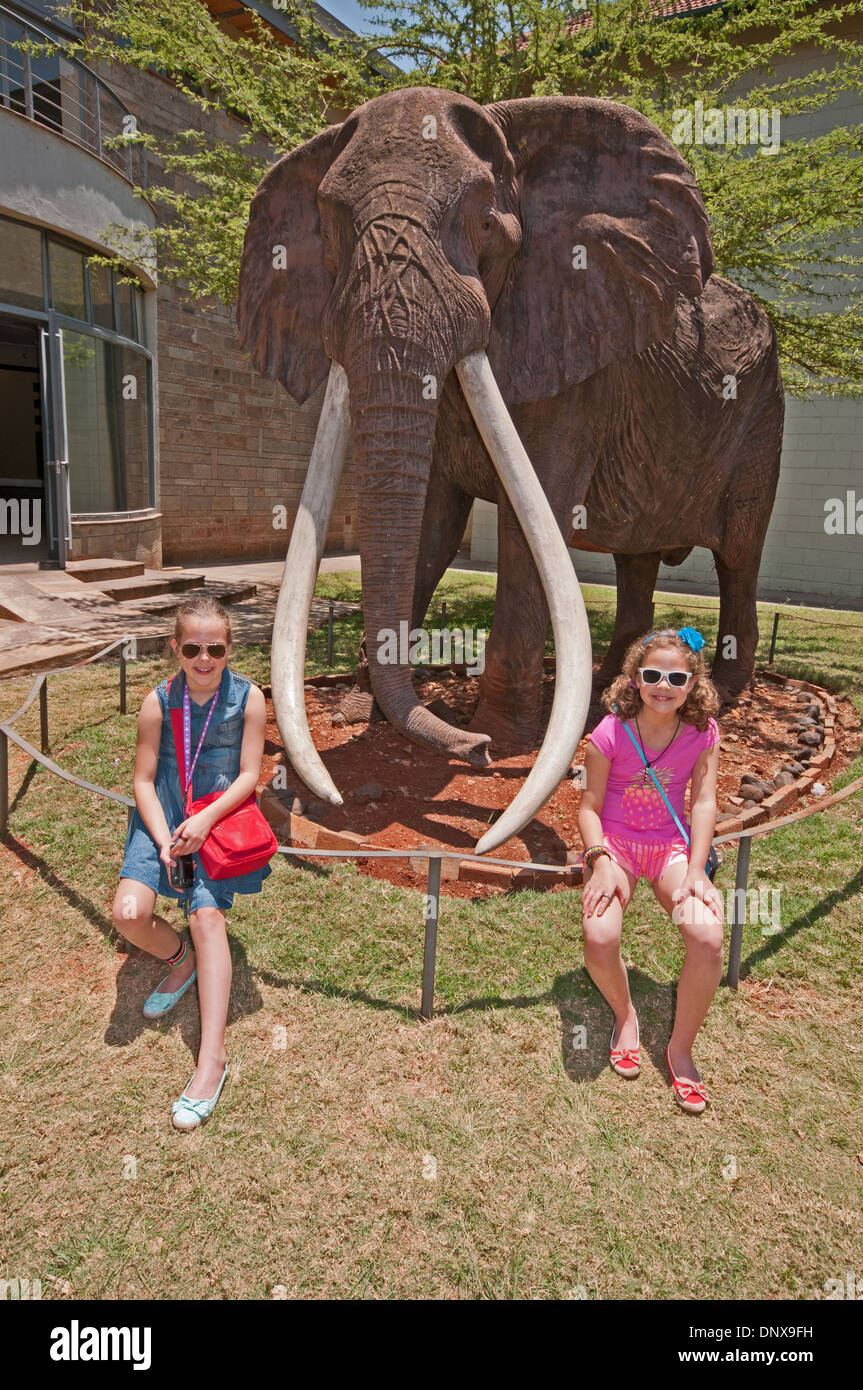 Two white Caucasian girls pose by life size effigy of Ahmed famous elephant of Marsabit in the Nairobi National Museum Kenya Stock Photo