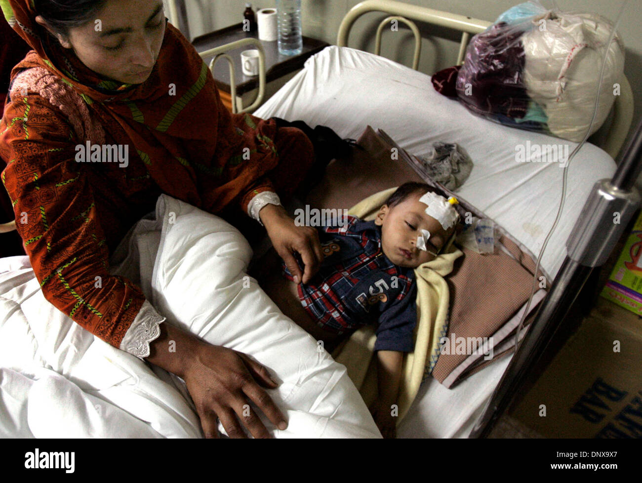 Dec 02, 2005; Islamabad, PAKISTAN; Aftermath of Pakistan earthquake on October 8, 2005. ADNAN (cq,age1) from Muzaffarabad, rests while at the Pakistan Institute of Medical Sciences Hospital  in Islamabad. ADNAN along with his family were living on the roof top when the earthquake hit , and he fell from the roof onto the ground.  ADNAN had to have surgery to his stomach to help repa Stock Photo