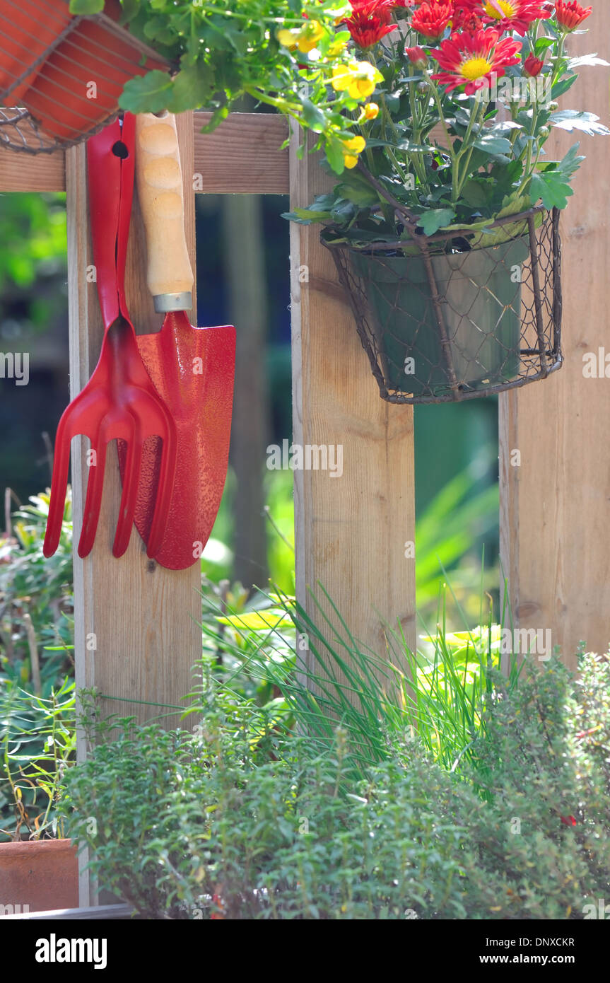 tools and flower pots hanging from a wooden barrier Stock Photo